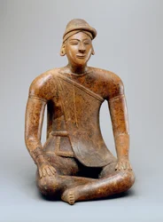 Hombre sentado con capa